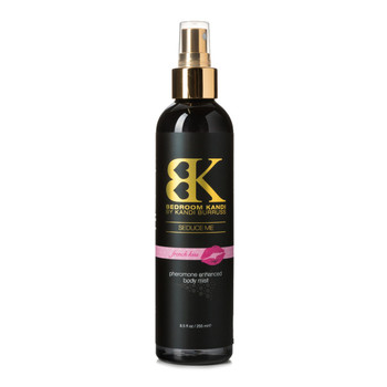 An image of a black round-topped bottle of Seduce Me pheromone enhanced body mist on a white background. The bottle has a gold pump-spray cap. The label reads French Kiss on a pink strip.